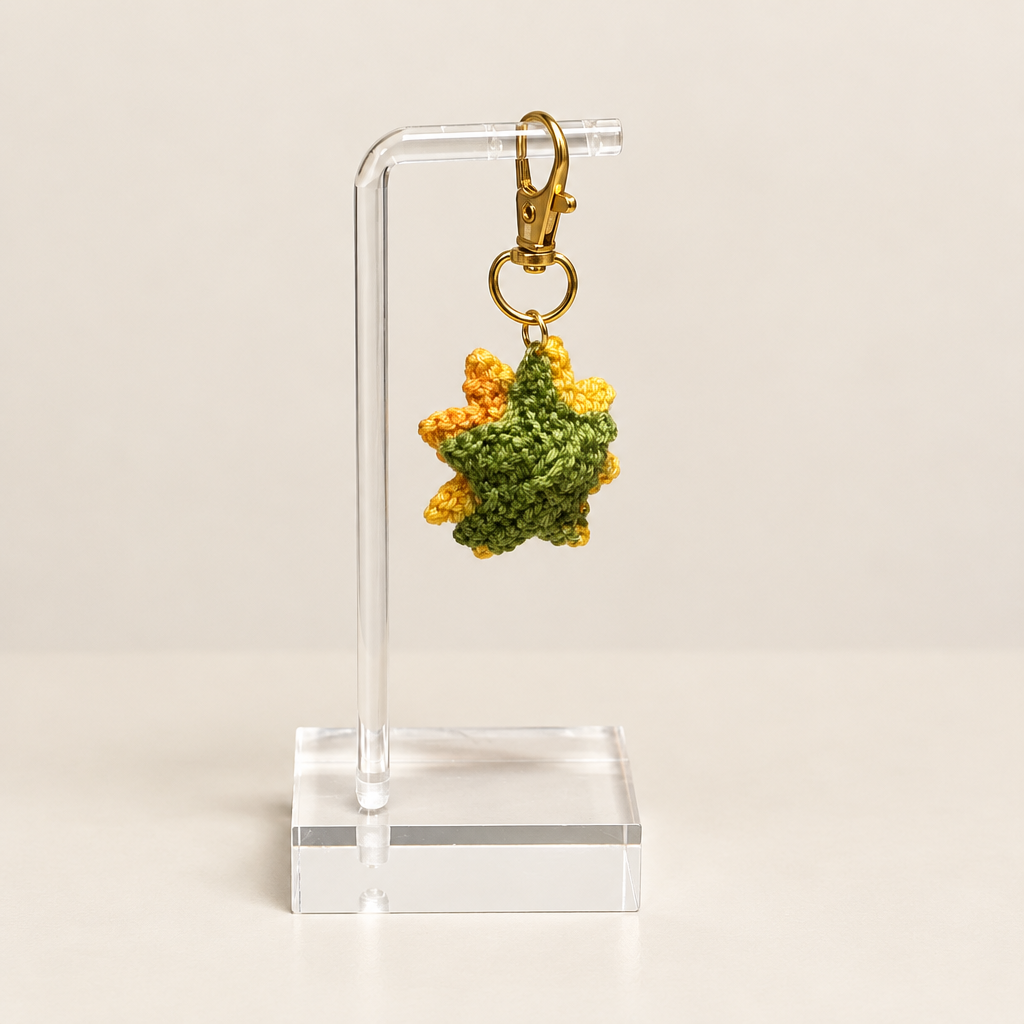 Green backing of the sunflower charm with yellow petals around the edges.